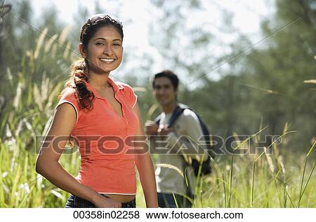 Stock Photo - Young couple hiking in the wilderness and smiling at camera. Fotosearch