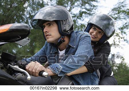 Stock Photo - Young couple riding motorbike. Fotosearch