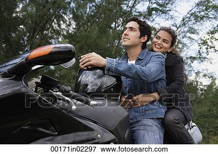 Young couple riding motorbike View Large Photo Image Stock Photo - Young couple riding motorbike. Fotosearch
