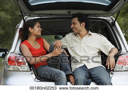 Young couple sitting in car boot View Large Photo Image Stock Image - Young couple sitting in car boot. Fotosearch