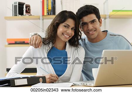 Stock Image - Young couple smiling at camera. Fotosearch
