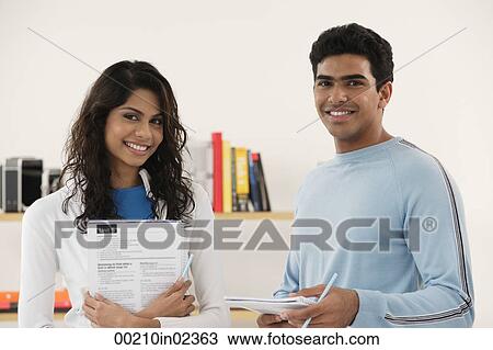 Stock Image - Young couple smiling at camera. Fotosearch
