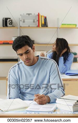 Young couple studying at desks View Large Photo Image Stock Photo - Young couple studying at desks. Fotosearch