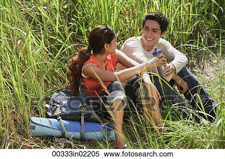 Young couple taking a break in high grass View Large Photo Image Stock Photography - Young couple taking a break in high grass. Fotosearch