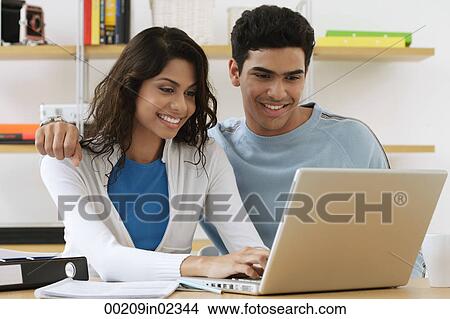 Young couple using laptop View Large Photo Image Picture - Young couple using laptop. Fotosearch