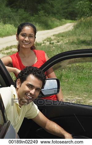 Young couple with car smiling at camera View Large Photo Image Stock Photo - Young couple with car smiling at camera. Fotosearch