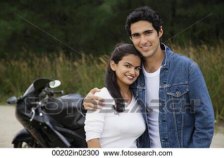 Young couple with motorbike smiling at camera View Large Photo Image Stock Image - Young couple with motorbike smiling at camera. Fotosearch