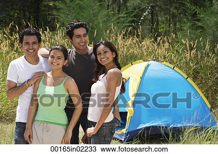 Young friends camping in the wilderness, smiling at camera View Large Photo Image Stock Image - Young friends camping in the wilderness, smiling at camera. Fotosearch