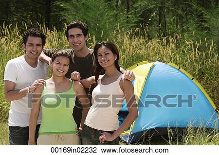 Young friends camping in the wilderness, smiling at camera View Large Photo Image Stock Image - Young friends camping in the wilderness, smiling at camera. Fotosearch