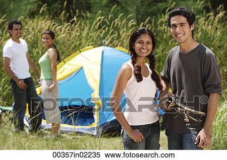 Stock Photography - Young friends camping in the wilderness, smiling at camera. Fotosearch