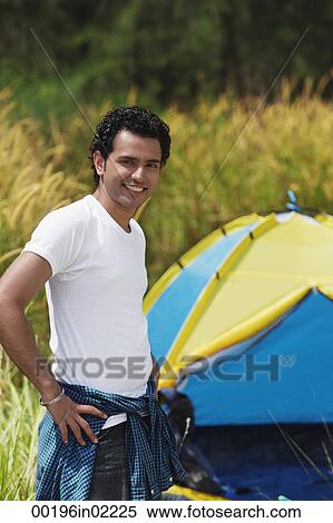 Young man camping smiling at camera View Large Photo Image Stock Photography - Young man camping smiling at camera. Fotosearch
