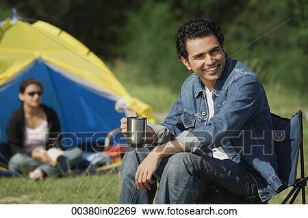 Stock Photo - Young man camping with girlfriend. Fotosearch