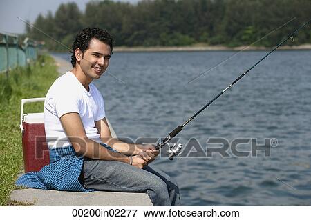 Young man fishing in river View Large Photo Image Stock Photo - Young man fishing in river. Fotosearch