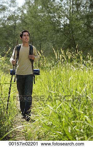 Young man hiking in the wilderness View Large Photo Image Stock Image - Young man hiking in the wilderness. Fotosearch