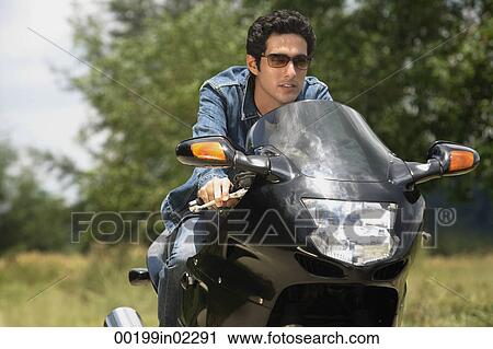Young man riding motorbike View Large Photo Image Stock Image - Young man riding motorbike. Fotosearch