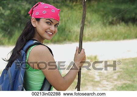 Young woman hiking and smiling at camera View Large Photo Image Stock Photo - Young woman hiking and smiling at camera. Fotosearch