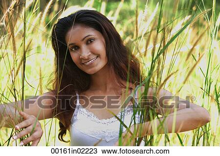 Young woman in high grass smiling at camera View Large Photo Image Stock Image - Young woman in high grass smiling at camera. Fotosearch