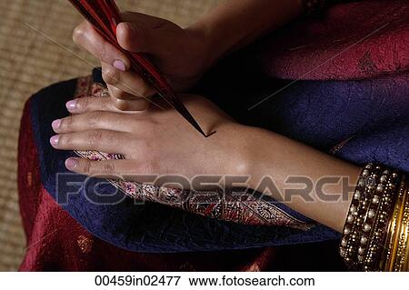 Stock Photo - Indian woman painting hand with henna. Fotosearch