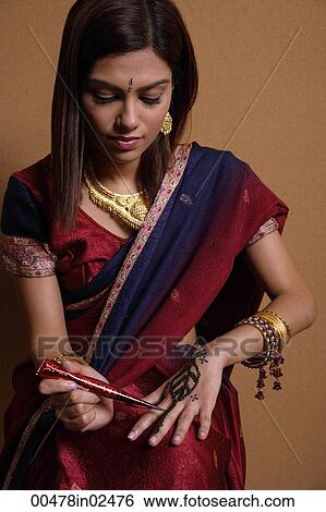 Indian woman painting hand with henna View Large Photo Image Stock Photograph - Indian woman painting hand with henna. Fotosearch