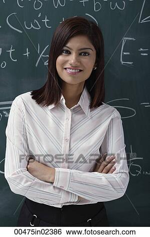 Stock Photograph - Teacher leaning against chalk board. Fotosearch