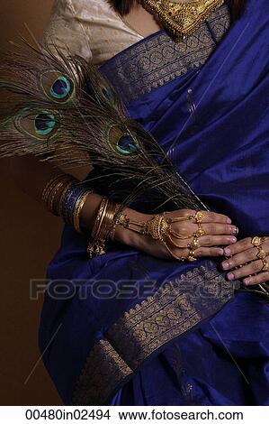 Picture - Torso of Indian woman holding peacock feathers. Fotosearch