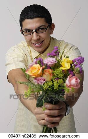 Stock Photography - Young man holding bouquet of flowers. Fotosearch
