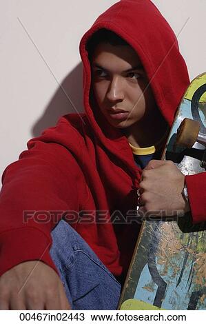 young man wearing red hooded sweatshirt holding skateboard View Large Photo Image Stock Image - young man wearing red hooded sweatshirt holding skateboard. Fotosearch