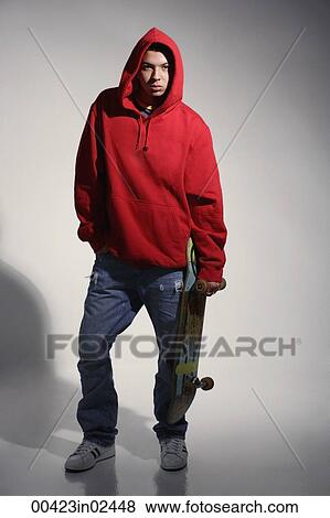 young man wearing red hooded sweatshirt holding skateboard View Large Photo Image Stock Photo - young man wearing red hooded sweatshirt holding skateboard. Fotosearch