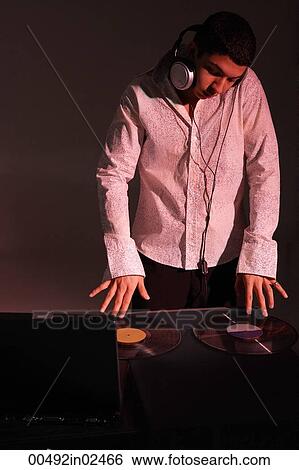 Stock Photograph - Young man working as DJ. Fotosearch