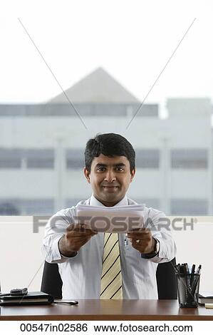Stock Photograph - business man handing over a stack of paper. Fotosearch