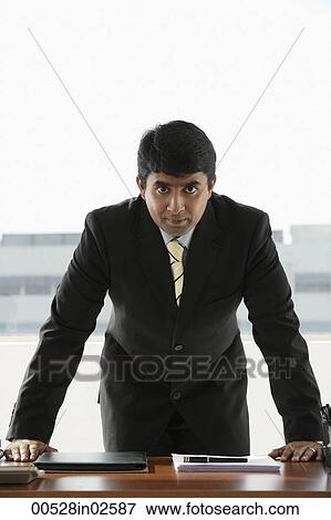 Stock Photo - business man standing at desk. Fotosearch