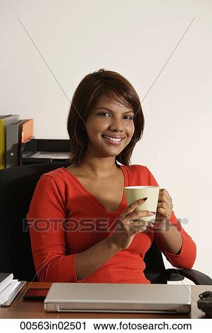 Business woman holding coffee mug, smiling at camera View Large Photo Image Stock Image - Business woman holding coffee mug, smiling at camera. Fotosearch