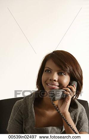 Stock Photo - Business woman smiling, talking on the phone. Fotosearch