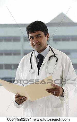 Picture - doctor holding patient file. Fotosearch