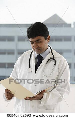 Stock Image - doctor looking at patient file. Fotosearch