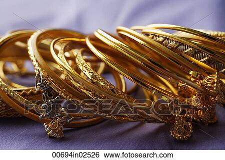 gold Indian bangles on purple sari cloth View Large Photo Image Stock Photograph - gold Indian bangles on purple sari cloth. Fotosearch