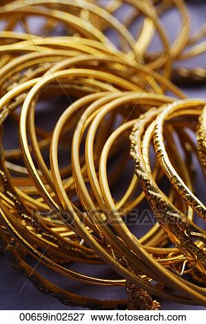 gold Indian bangles on purple sari cloth closeup View Large Photo Image Stock Photo - gold Indian bangles on purple sari cloth closeup. Fotosearch