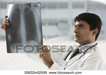 Stock Photo - indian doctor holding up x-ray scan. Fotosearch