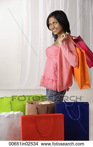 indian woman in pink blouse holding many shopping bags View Large Photo Image Picture - indian woman in pink blouse holding many shopping bags. Fotosearch