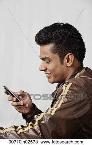 side profile of young man in jacket, using mobile phone View Large Photo Image Stock Image - side profile of young man in jacket, using mobile phone. Fotosearch