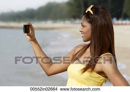 Side view of woman taking a picture View Large Photo Image Picture - Side view of woman taking a picture. Fotosearch