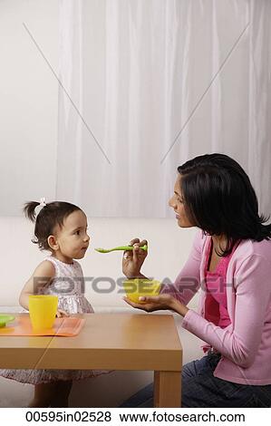 woman feeding food to her baby View Large Photo Image Stock Photo - woman feeding food to her baby. Fotosearch