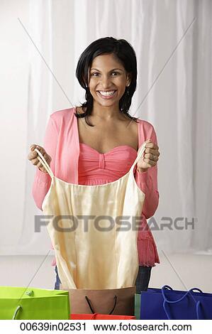 woman in pink blouse pulling dress out from shopping bag View Large Photo Image Stock Image - woman in pink blouse pulling dress out from shopping bag. Fotosearch