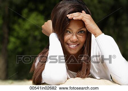 woman lying in sand, shielding her eyes View Large Photo Image Stock Image - woman lying in sand, shielding her eyes. Fotosearch