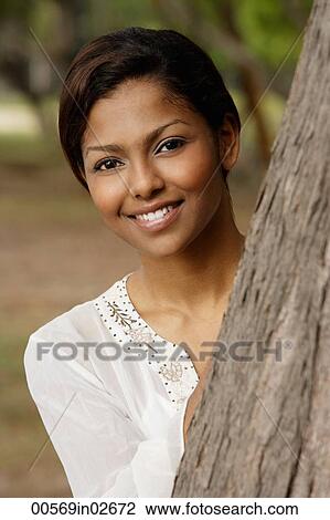 woman peeking out from behind a tree View Large Photo Image Stock Image - woman peeking out from behind a tree. Fotosearch