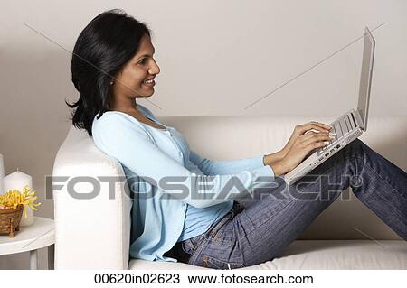 woman sitting on couch, using laptop View Large Photo Image Stock Image - woman sitting on couch, using laptop. Fotosearch