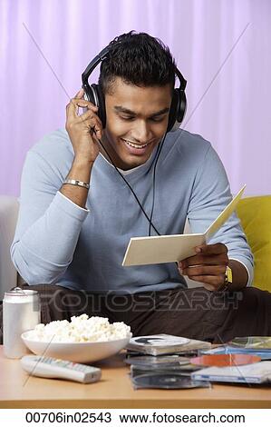 Stock Image - young man listening to music with headphones on. Fotosearch