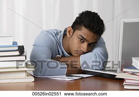 young man sitting at his desk, moody View Large Photo Image Stock Image - young man sitting at his desk, moody. Fotosearch