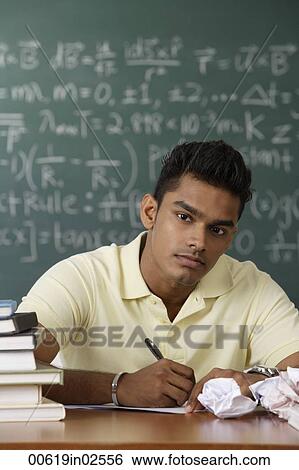 young man sitting at his desk, writing View Large Photo Image Stock Photograph - young man sitting at his desk, writing. Fotosearch