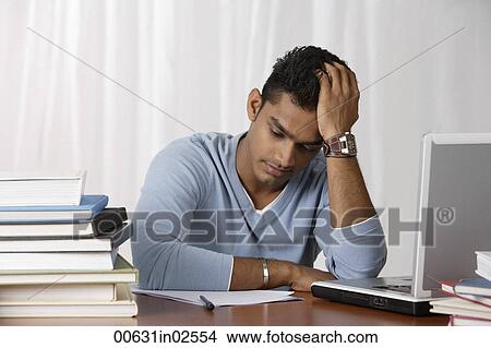 young man studying at his desk, stressed View Large Photo Image Picture - young man studying at his desk, stressed. Fotosearch